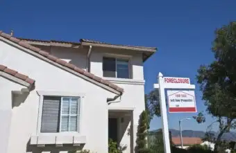 House with foreclosure sign and for sale sign