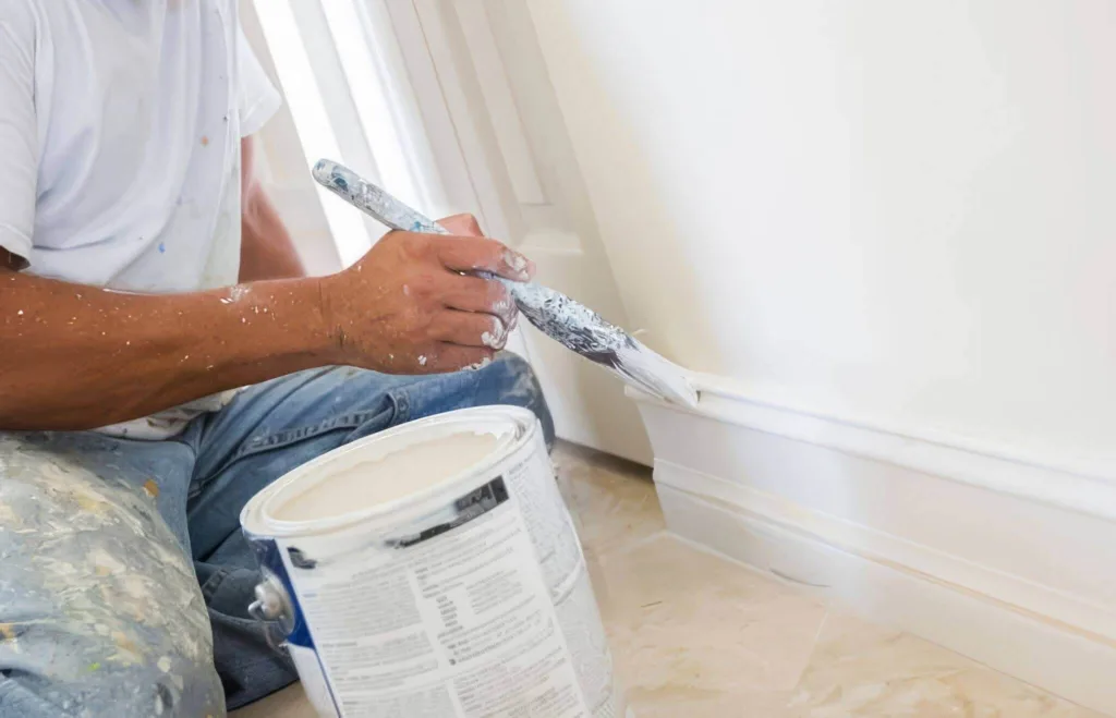 Applying white paint to trim in a lounge