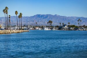 Beautiful view of Channel Islands Harbor in Oxnard, CA with palm trees and mountains in the background.