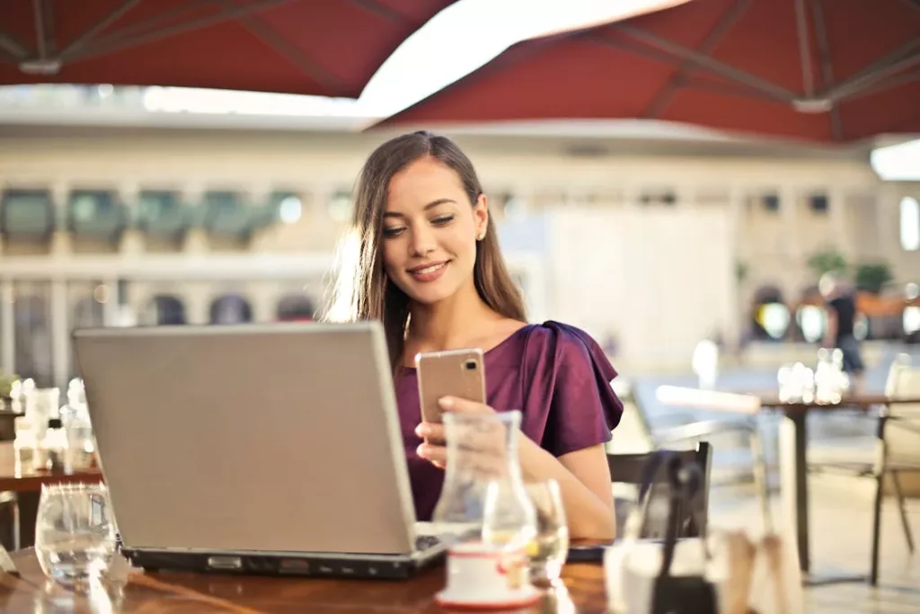 A woman looks hopeful as she makes a mortgage payment on her mobile phone.