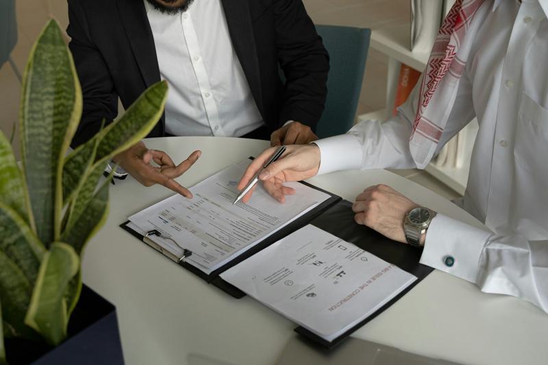Two professionals reviewing home disclosure documents during a real estate meeting. 