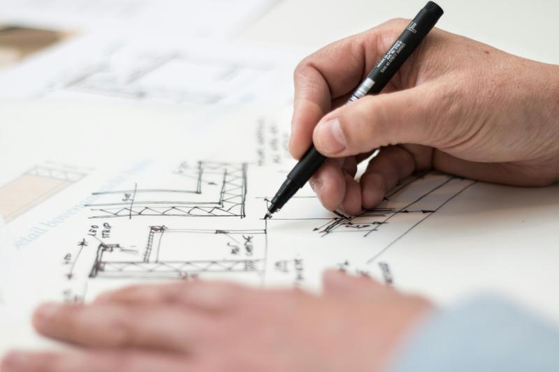 Hand sketching DIY renovation plans without professional blueprints or permits.