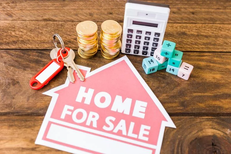 Home sale sign with keys, coins, and a calculator in California.