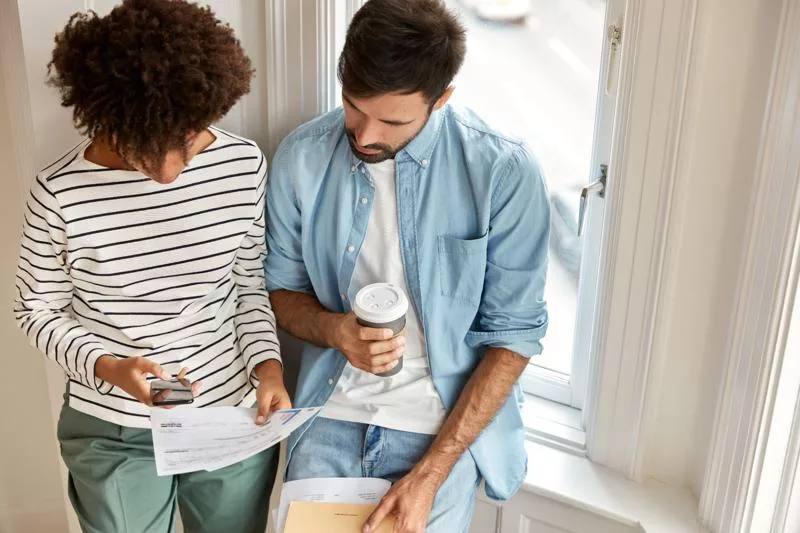 Couple reviewing documents and costs to sell a house in California.