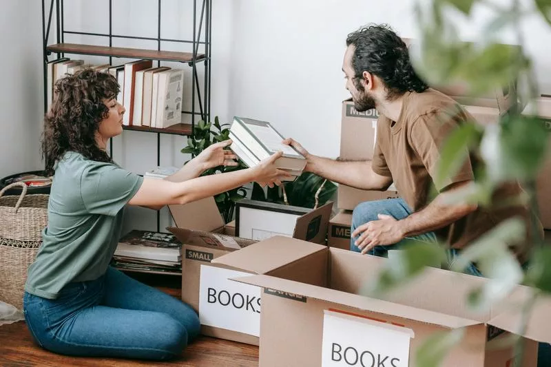 Two people sorting and boxing books after a family death.