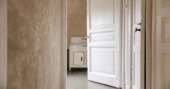 Interior hallway with open white-painted door and vintage sink