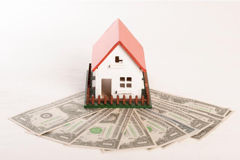 Mini house model with cash spread out underneath