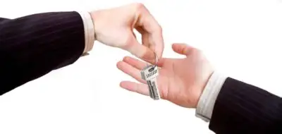 Homeowner handing over keys symbolizing a rent-to-own transaction.