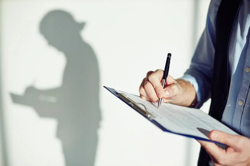 Seller writing out a disclosure forms on a clipboard with shadow in background