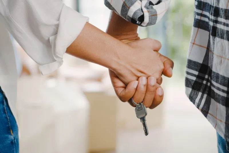 Couple holding hands and house keys, preparing for a FSBO home sale