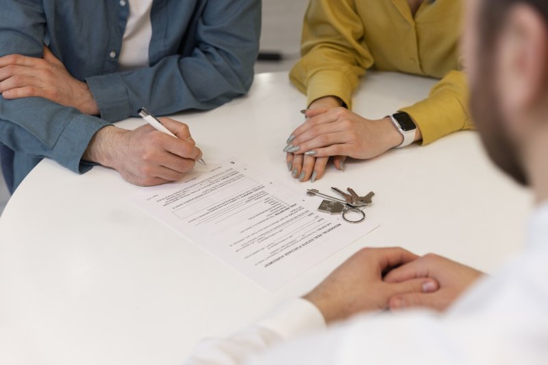 Beneficiaries signing trust administration documents with house keys for inherited California property transfer